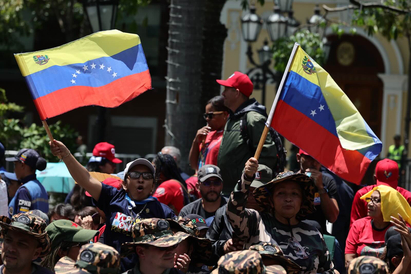 Spectators wave Venezuelan flags during a military parade in the country.
