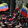 Spectators wave Venezuelan flags during a military parade in the country.