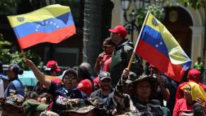 Spectators wave Venezuelan flags during a military parade in the country.