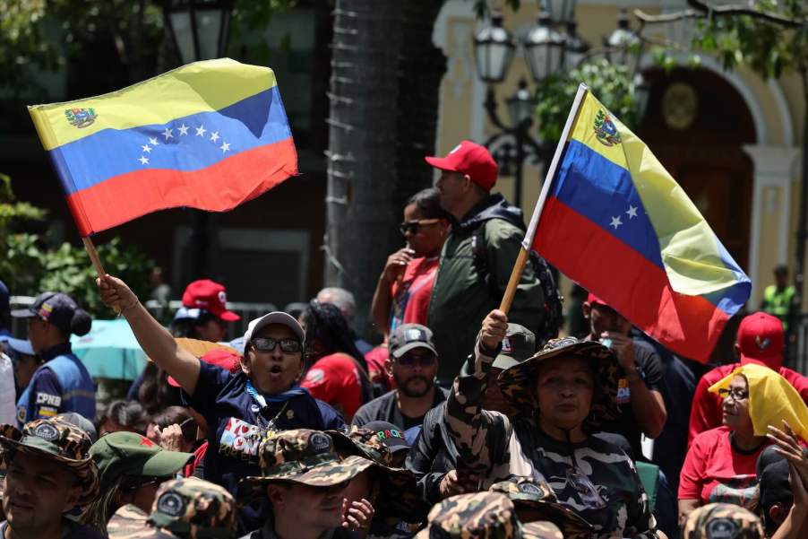 Spectators wave Venezuelan flags during a military parade in the country.