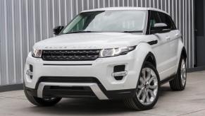 White Ranger Rover Evoque parked in front of a shipping container.