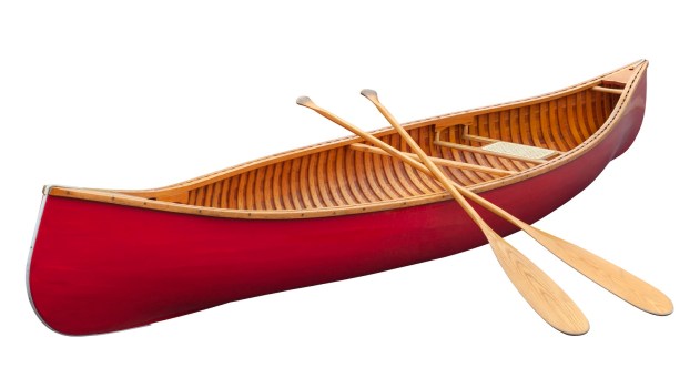 Bright red canoe with two wooden paddles leaned against it.