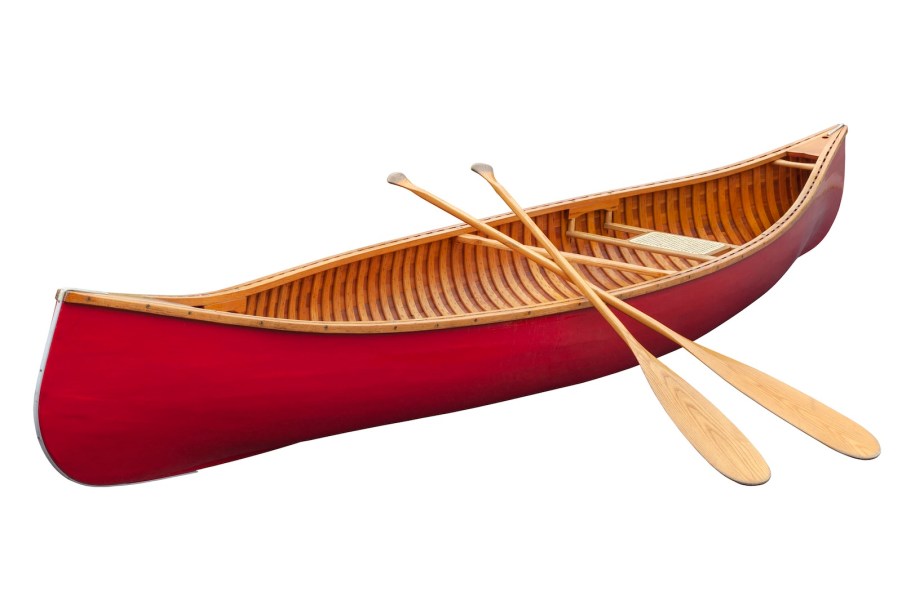 Bright red canoe with two wooden paddles leaned against it.