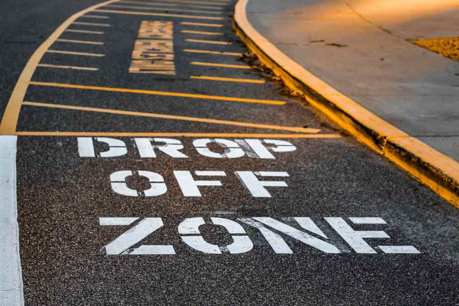 The "drop off zone" paint on the tarmac of a school parking lot.