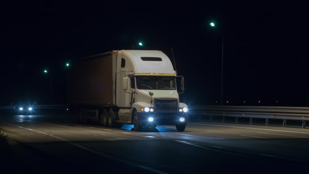 White semi truck on Florida highway at night.