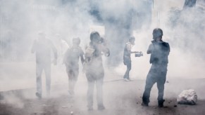 People standing in the middle of tear gas