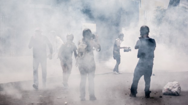 People standing in the middle of tear gas