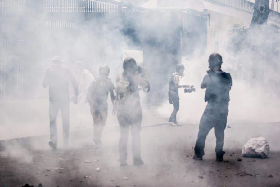 People standing in the middle of tear gas