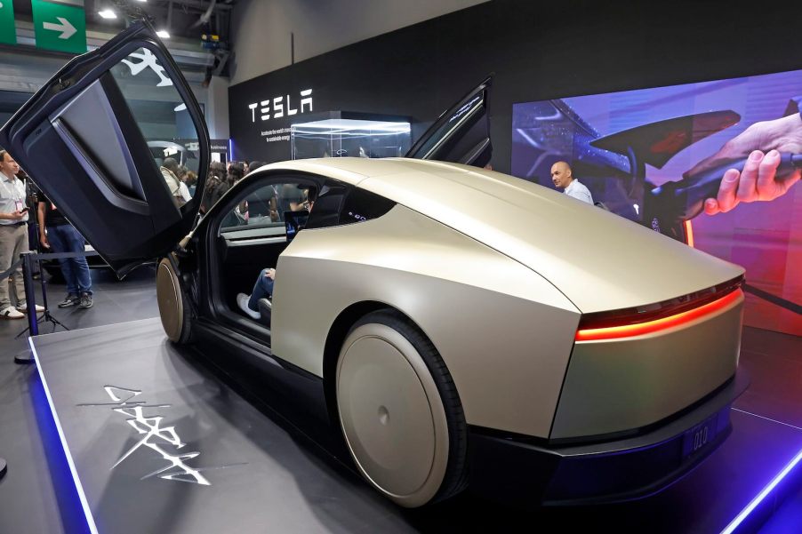 Beige Tesla Cybercab with its gullwing doors open.