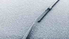 Windshield wiper in service mode points directly up, snow visible in the background.