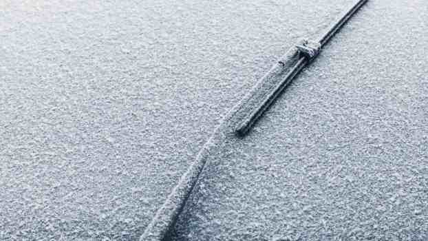 Windshield wiper in service mode points directly up, snow visible in the background.