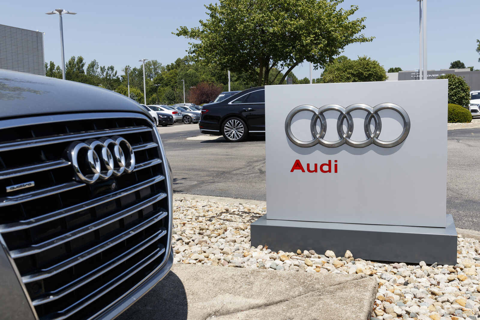 Audi dealership entrance sign with vehicle grill in close foreground
