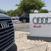 Audi dealership entrance sign with vehicle grill in close foreground