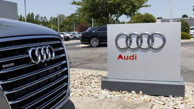 Audi dealership entrance sign with vehicle grill in close foreground