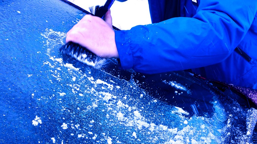 man-scraping-ice-off-car-windshield