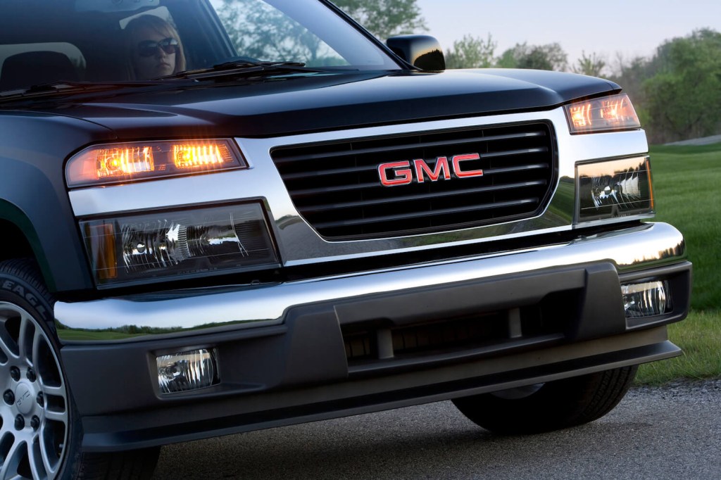 Woman drives a midsize GMC Canyon pickup truck.
