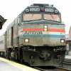 The engine of an Amtrak train, parked at a station.