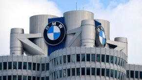 The BMW logo on top of an office building, blue sky in the background.