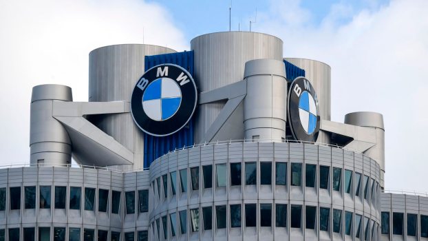 The BMW logo on top of an office building, blue sky in the background.