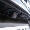 The backup camera above the license plate of a car.