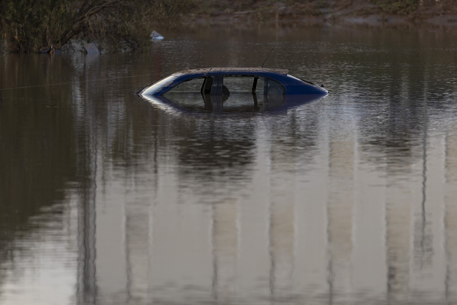 The rooftop of a car sinking into water.