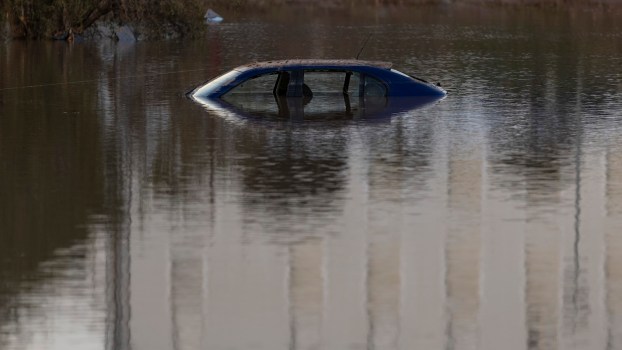 The rooftop of a car sinking into water.