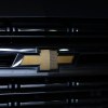 The gold bowtie logo on a black Silverado EV pickup truck grill.