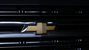 The gold bowtie logo on a black Silverado EV pickup truck grill.