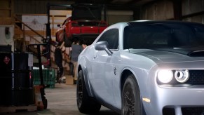 Silver Dodge Challenger Hellcat Demon muscle car in garage.