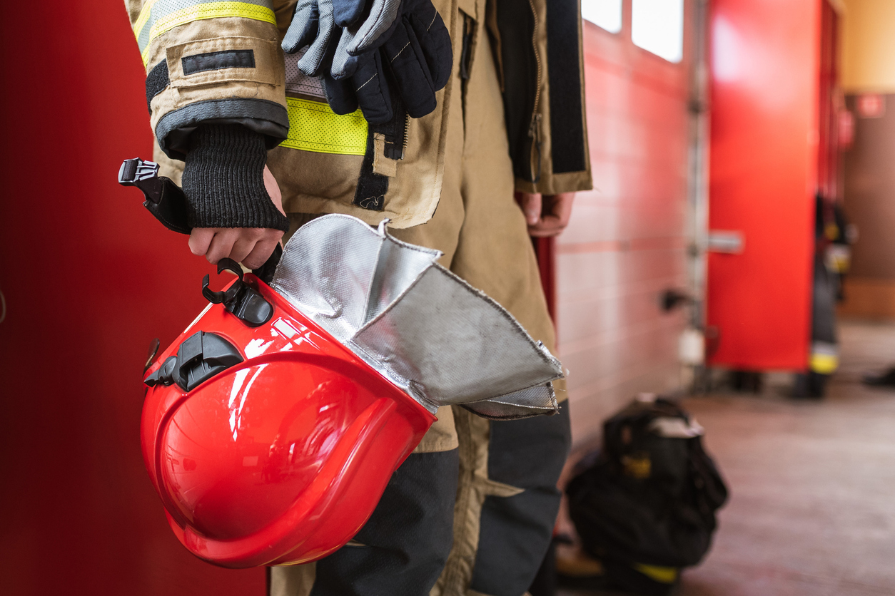 A firefighter holding a helmet