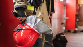 A firefighter holding a helmet