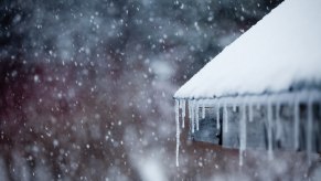 Icicles hanging from a roof during a snow storm.