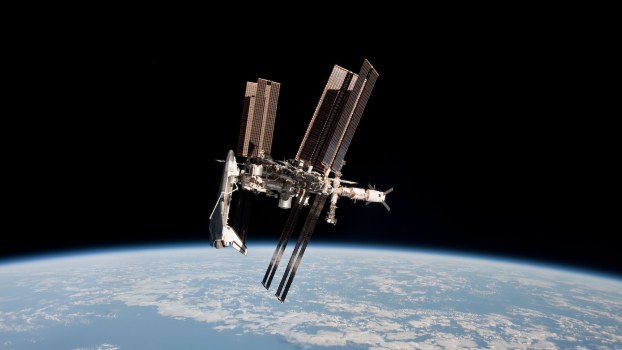 A shuttle docks to the International Space Station, the planet Earth visible in the background.