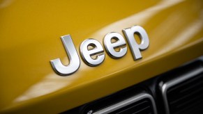 Chrome Jeep logo on the gold hood of an SUV.