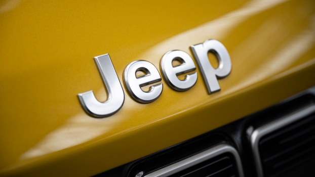 Chrome Jeep logo on the gold hood of an SUV.