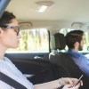 Woman texts on her phone while riding in a Lyft taxi car