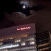 The Nissan sign above the headquarters office building in Japan, a full moon in the background.