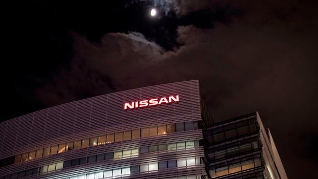 The Nissan sign above the headquarters office building in Japan, a full moon in the background.