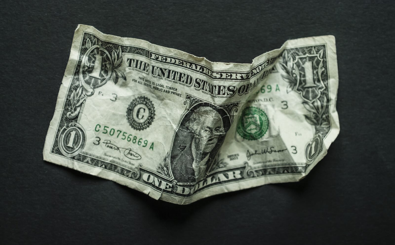 $1 bill on a black background.