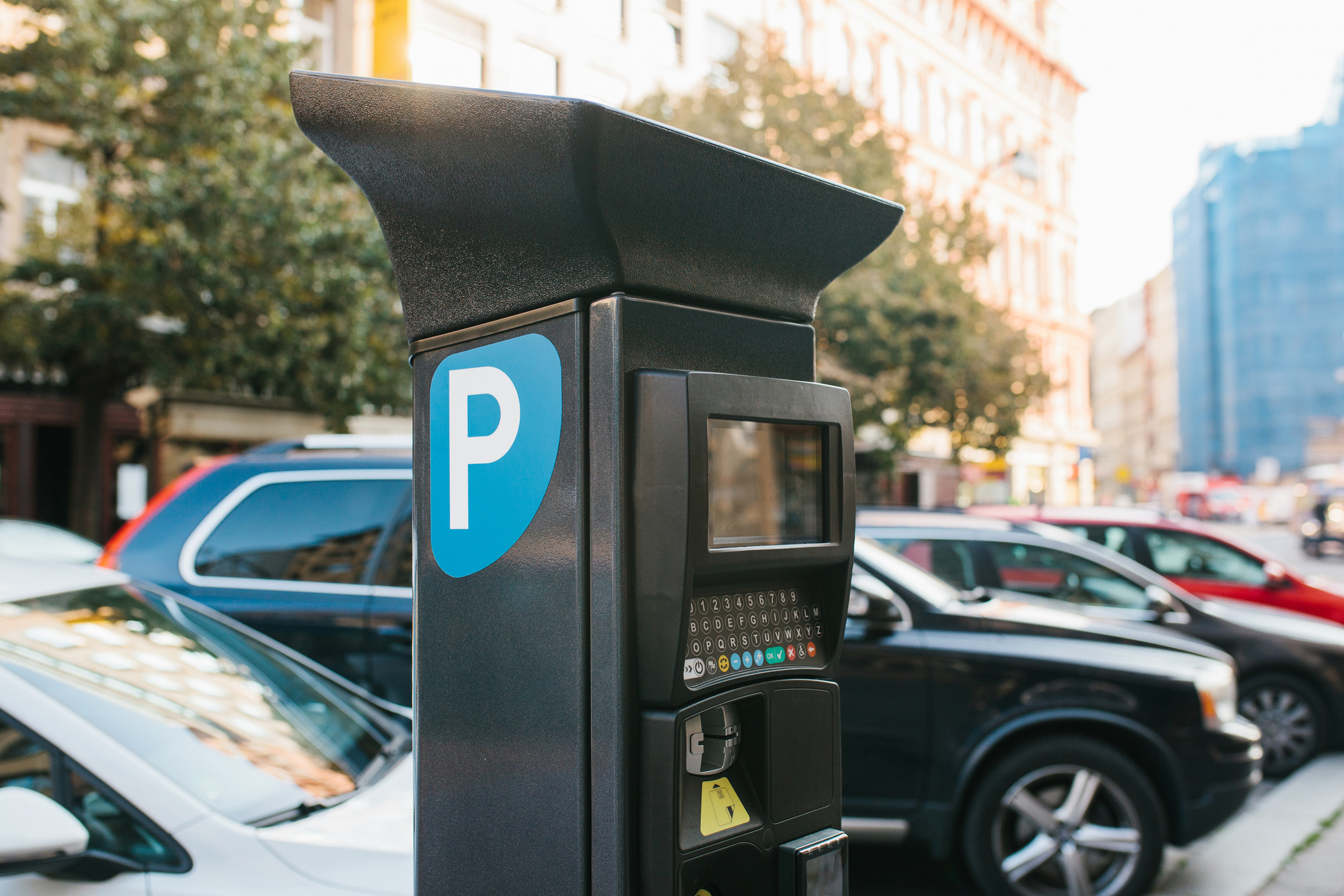 A parking meter in front of cars