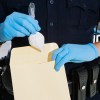 A police officer putting drugs in an envelope