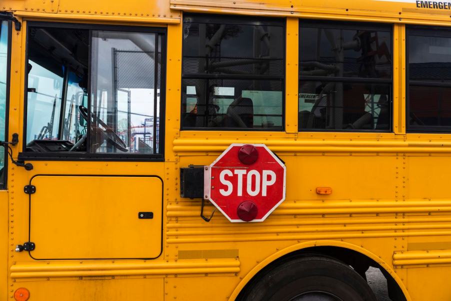 Red sign on a yellow school bus at a Florida stop.