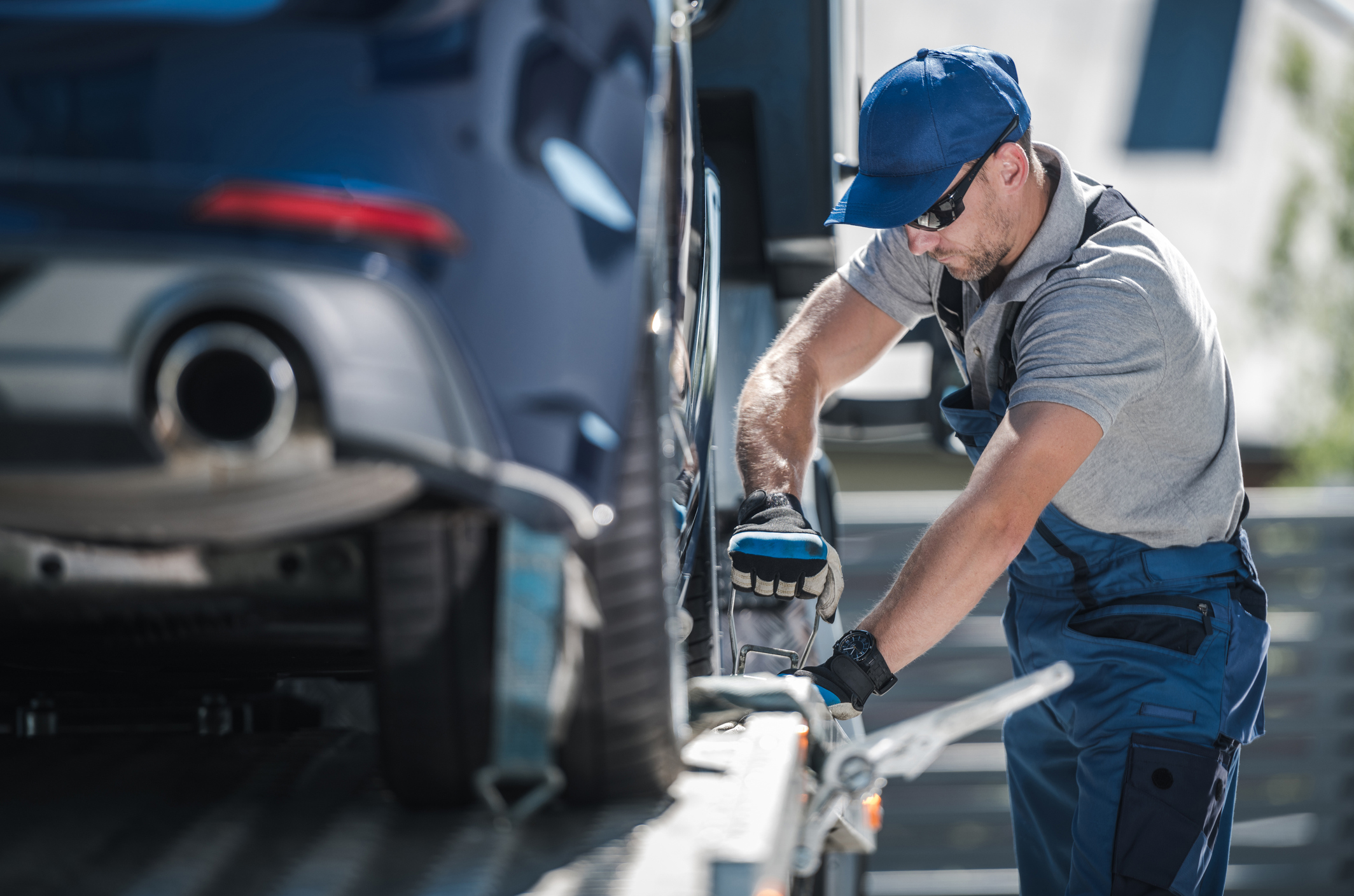 A tow truck operator loading a car