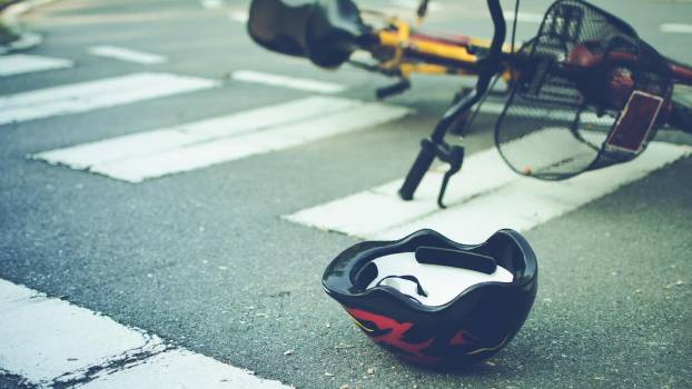 eBike left in crosswalk after a crash, helmet in the foreground.