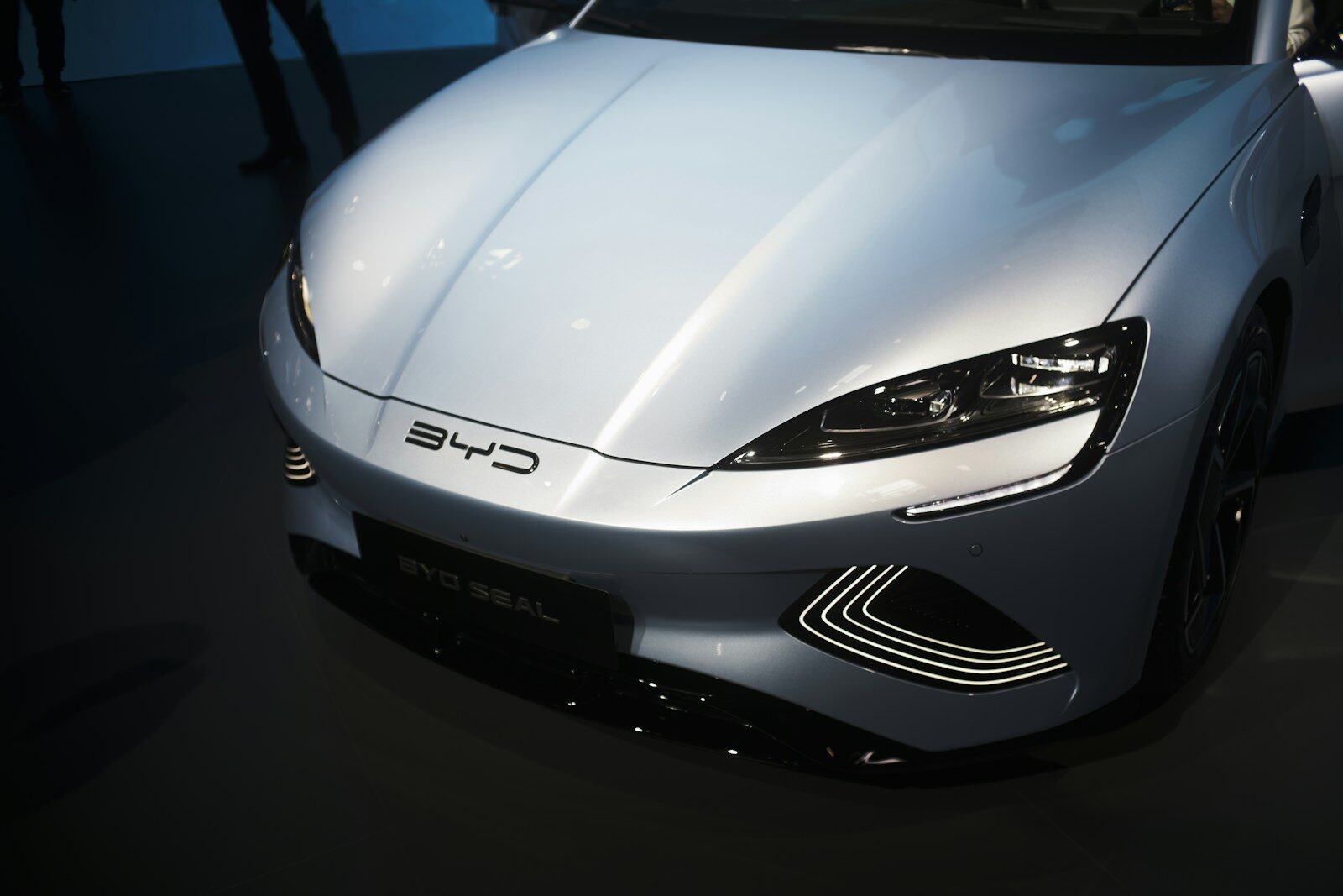 a white chinese car is on display at a car show