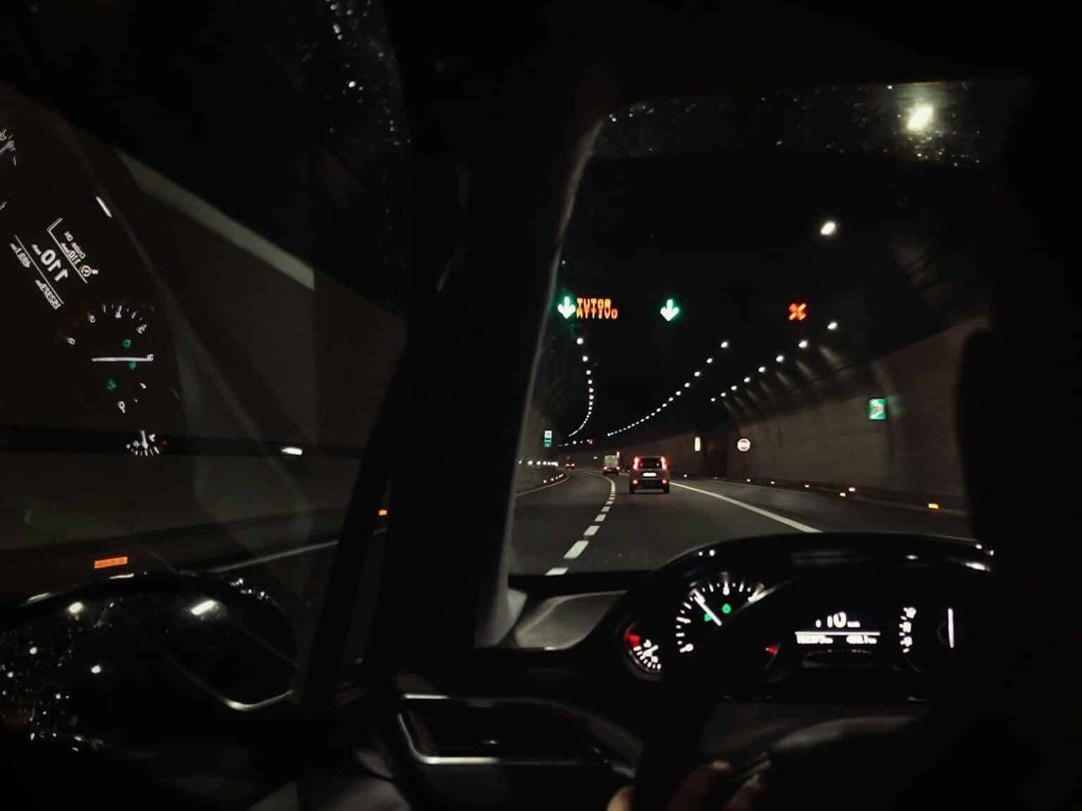 a car driving down a highway at night