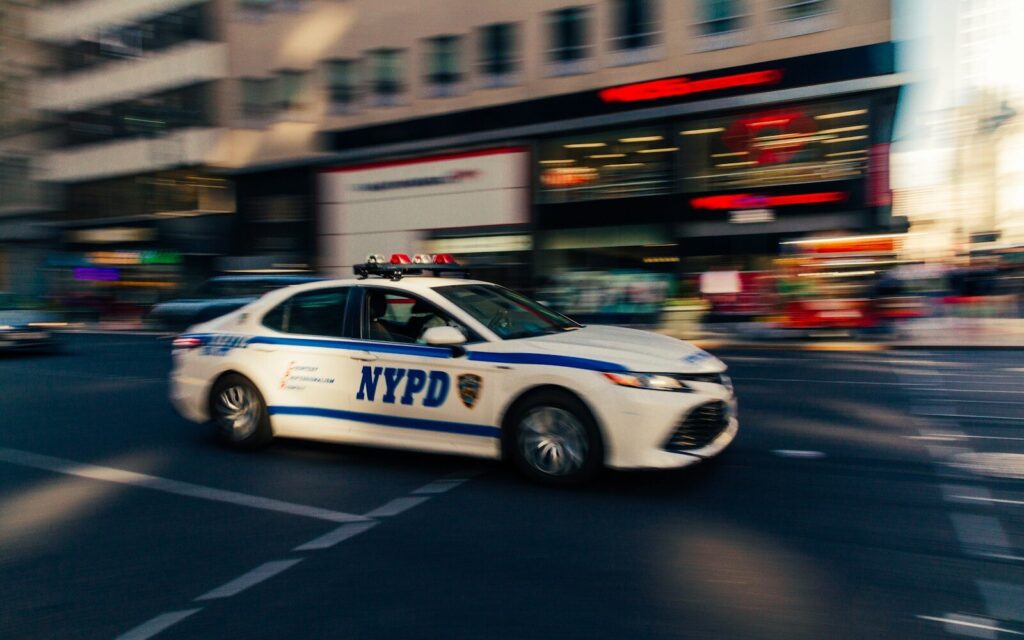 a police car driving down a city street to hyundai tucson accident scene