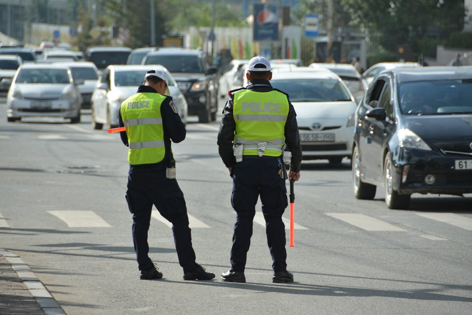 two police officers standing on the side of a road.