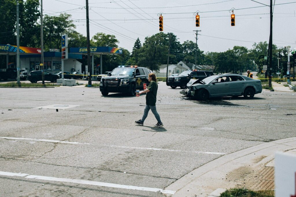 a man walking across a street next to a car