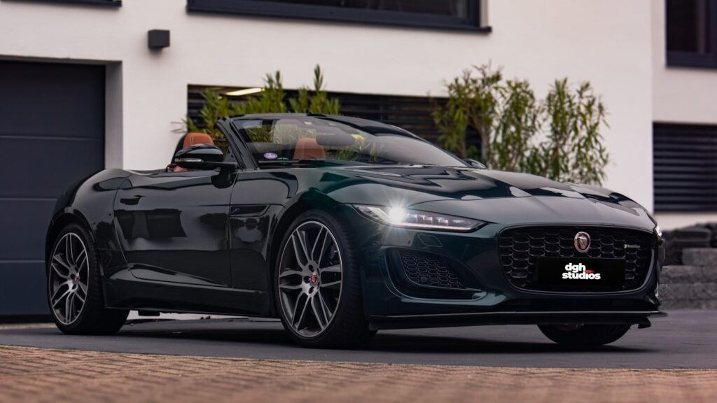 A black sports car parked in front of a house. Jaguar F-Type